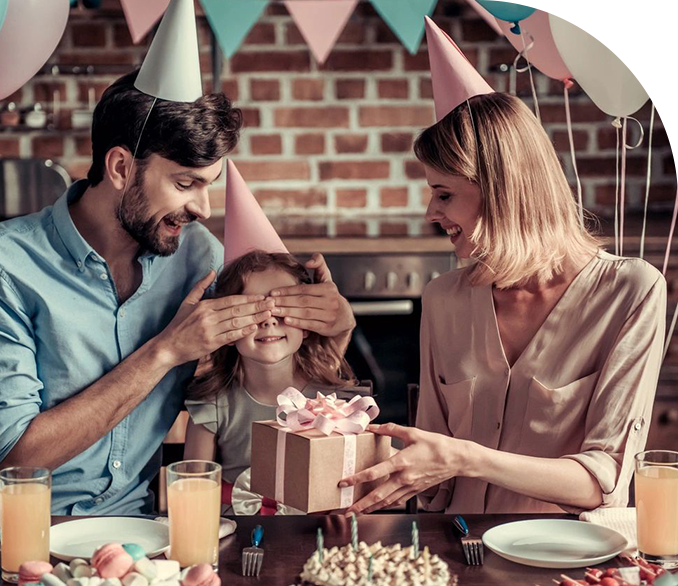 A family celebrating with cake and drinks at the table.