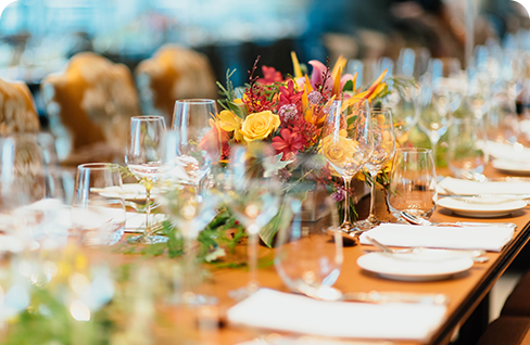 A table with wine glasses and flowers on it.