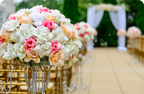 A row of chairs with flowers in them.