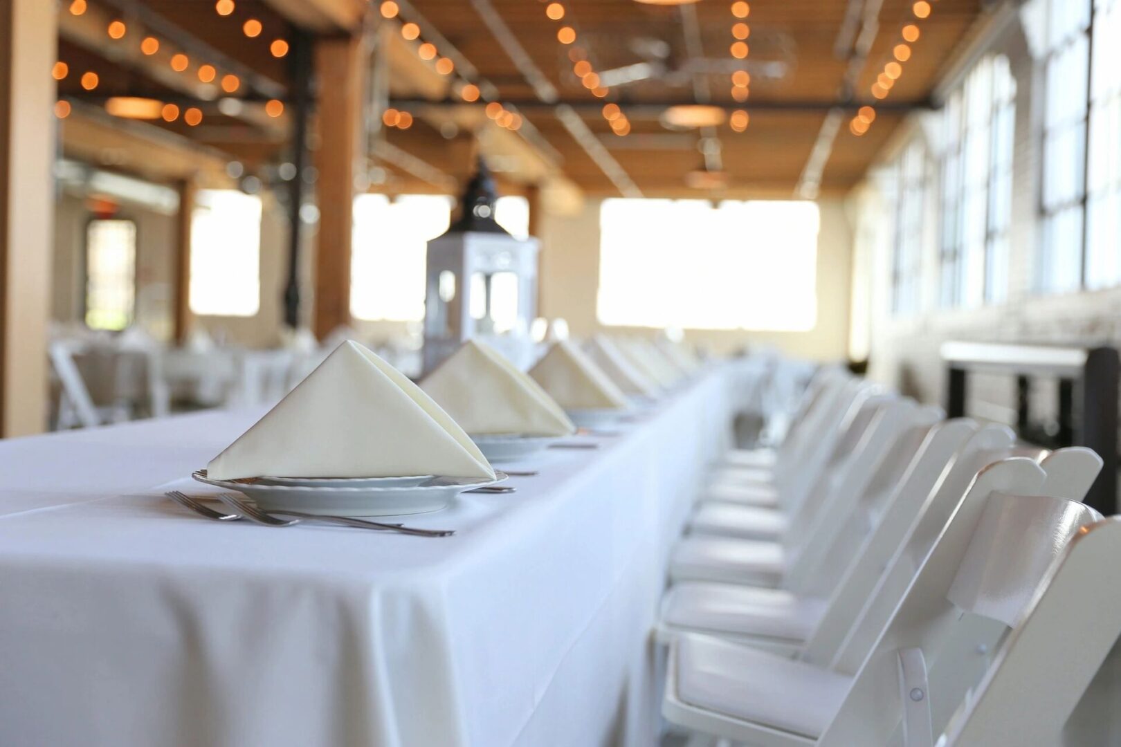 A table with white linen and napkins on it