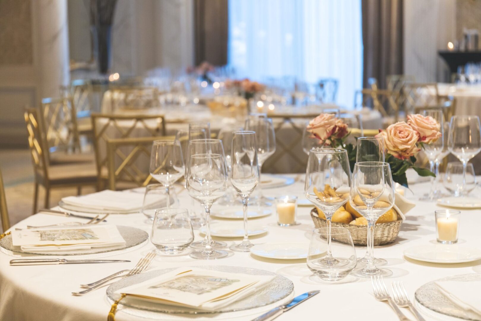 A table set with wine glasses and plates.