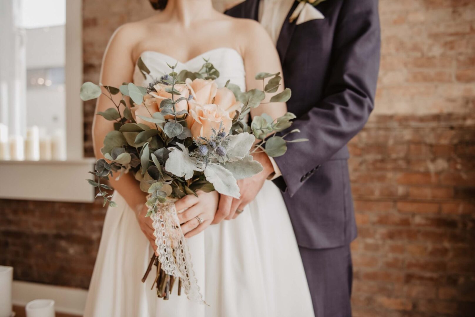 A bride and groom holding their wedding bouquet.