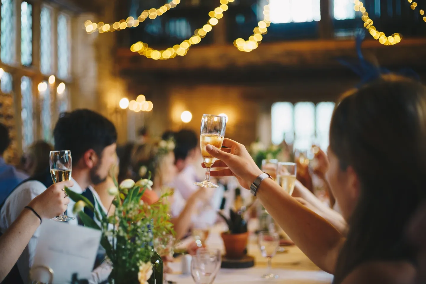 A group of people sitting at tables with wine glasses.