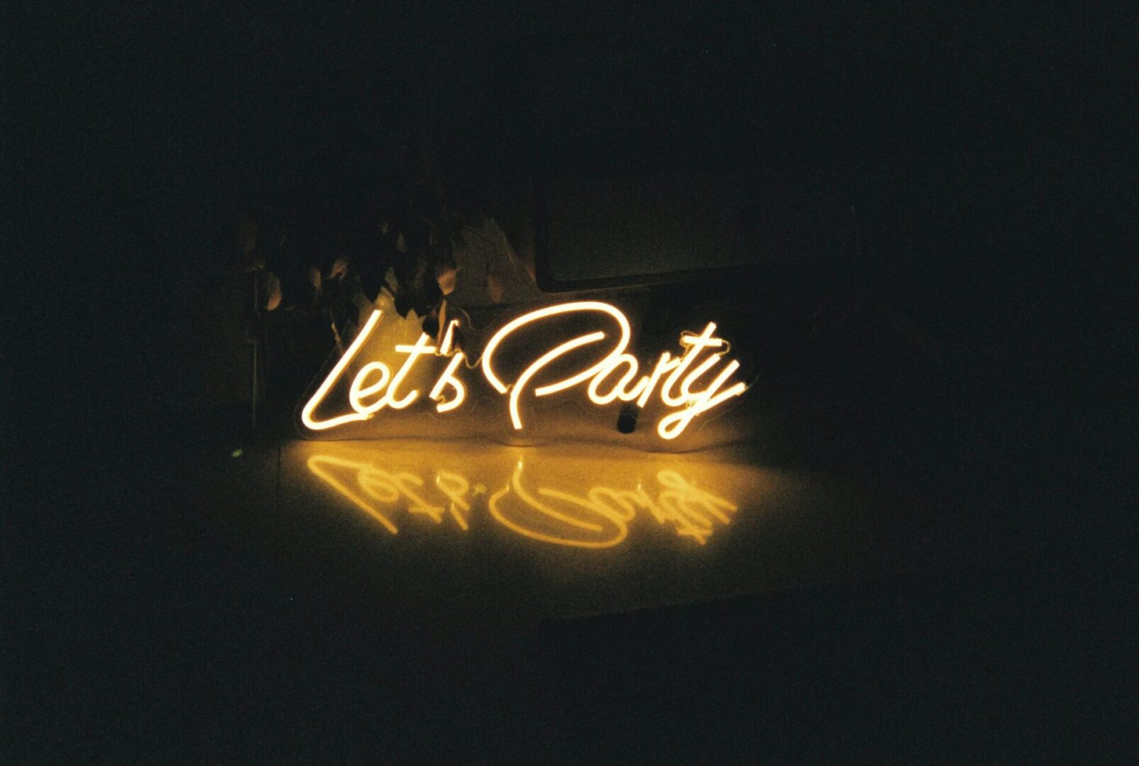 A neon sign that says let 's party.